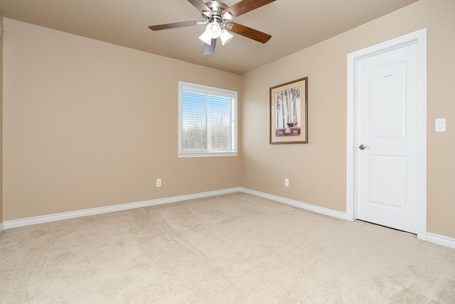 carpeted spare room featuring ceiling fan