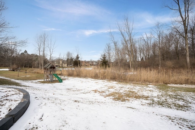 yard covered in snow with a playground