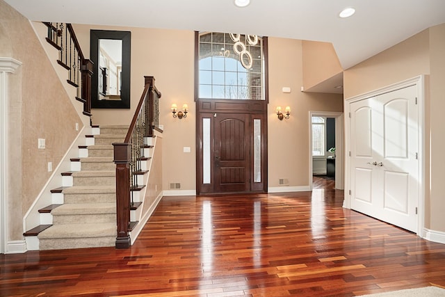 entrance foyer with dark wood-type flooring and a chandelier