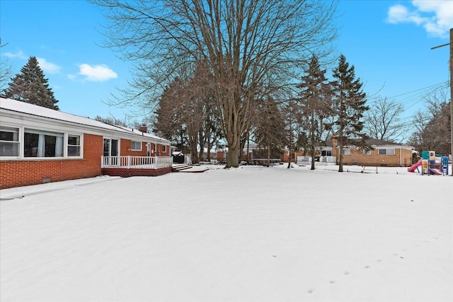 yard layered in snow with a playground