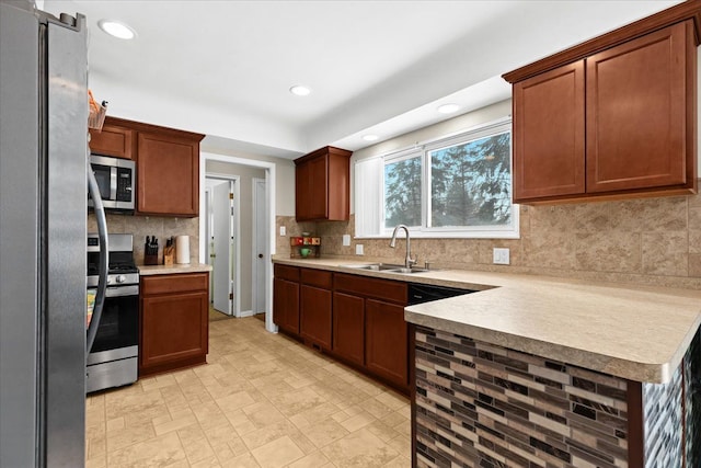 kitchen with appliances with stainless steel finishes, sink, and decorative backsplash