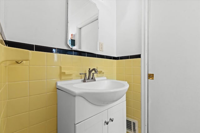 bathroom with vanity and tile walls