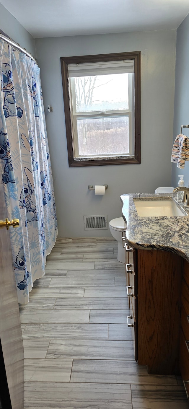 bathroom featuring vanity and toilet