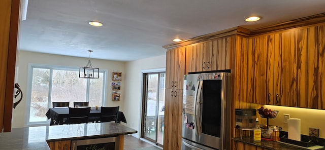 kitchen featuring wine cooler, stainless steel refrigerator, kitchen peninsula, pendant lighting, and dark stone counters