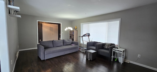 living area with dark wood-type flooring and baseboards