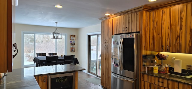 kitchen with stainless steel refrigerator, decorative light fixtures, wine cooler, tile patterned flooring, and kitchen peninsula