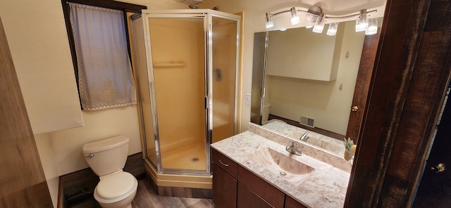 bathroom with vanity, a shower with shower door, and toilet