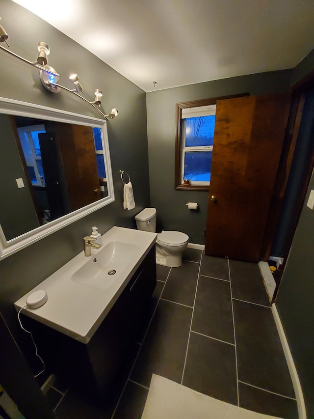 bathroom featuring vanity, tile patterned floors, and toilet