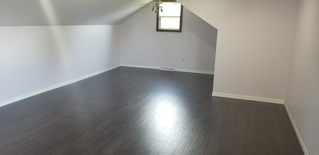 additional living space featuring lofted ceiling and dark wood-type flooring