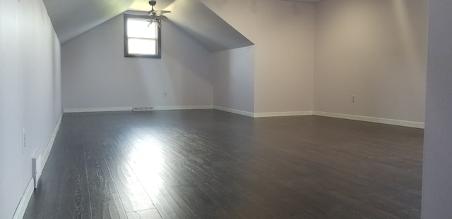 additional living space with dark hardwood / wood-style floors and vaulted ceiling