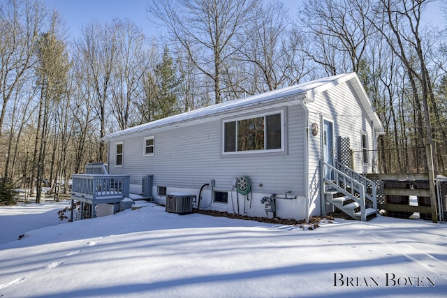 view of snow covered exterior featuring a deck and central air condition unit