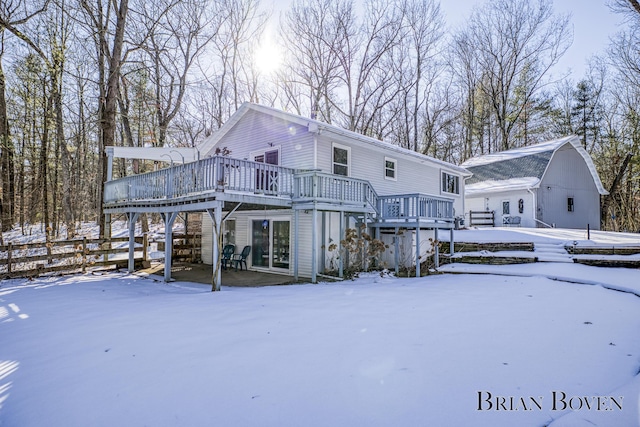 snow covered house featuring a wooden deck