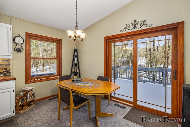 dining room with vaulted ceiling and a notable chandelier