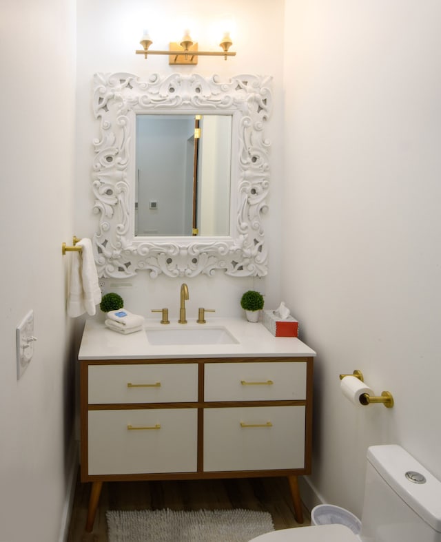 bathroom featuring vanity, hardwood / wood-style flooring, and toilet