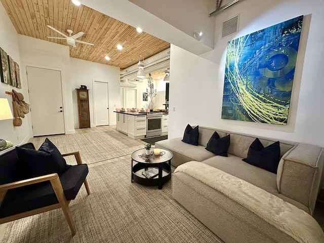 carpeted living room with wooden ceiling and a high ceiling