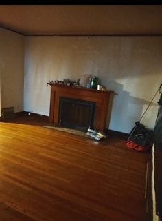 unfurnished living room with a fireplace with flush hearth and wood finished floors