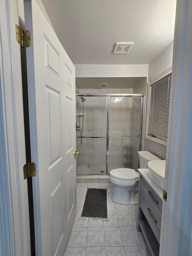 bathroom featuring vanity, an enclosed shower, tile patterned flooring, and toilet