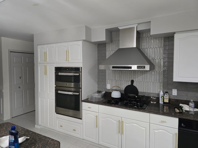 kitchen featuring wall chimney exhaust hood, double oven, decorative backsplash, and white cabinets