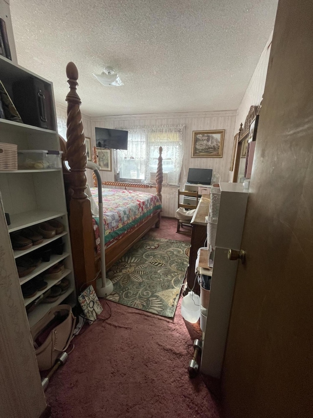 carpeted bedroom with a textured ceiling and ornamental molding