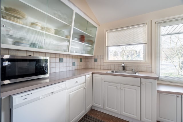 kitchen featuring lofted ceiling, a sink, white cabinets, dishwasher, and stainless steel microwave