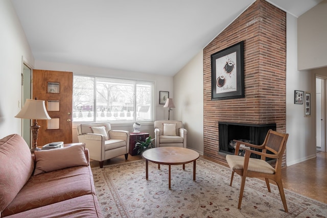 living area with high vaulted ceiling, light wood-style floors, a fireplace, and baseboards