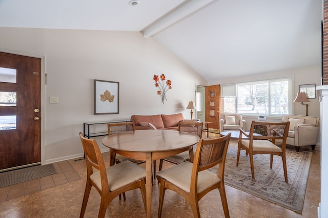 dining room with lofted ceiling with beams, light tile patterned floors, and baseboards