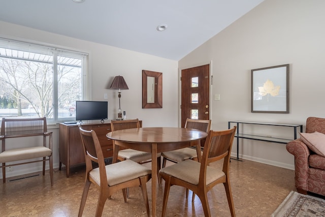 dining room featuring lofted ceiling and baseboards