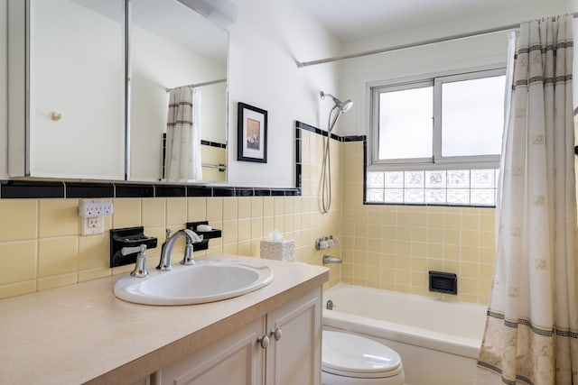 bathroom featuring tile walls, tasteful backsplash, shower / bathtub combination with curtain, toilet, and vanity