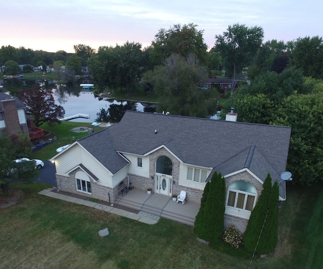 aerial view at dusk featuring a water view