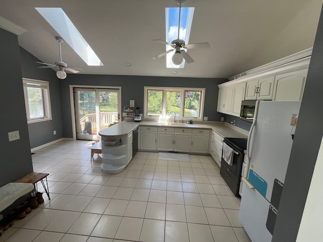 kitchen with a healthy amount of sunlight, kitchen peninsula, light tile patterned floors, and black appliances