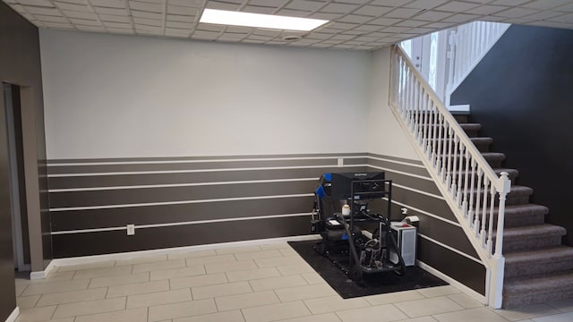 staircase with a paneled ceiling