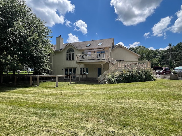 back of house with a lawn and a deck