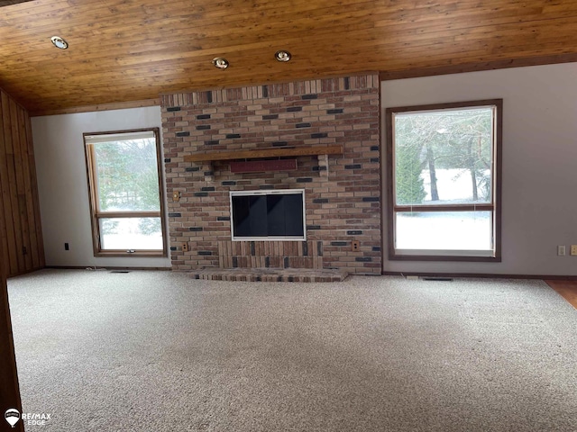 unfurnished living room with vaulted ceiling, carpet flooring, and wood ceiling