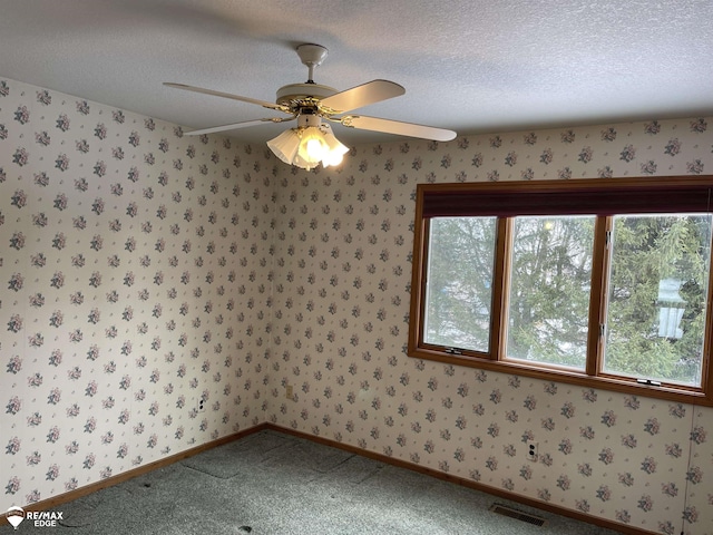 carpeted empty room with a textured ceiling