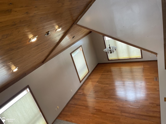 additional living space with hardwood / wood-style flooring, lofted ceiling, a chandelier, and wooden ceiling