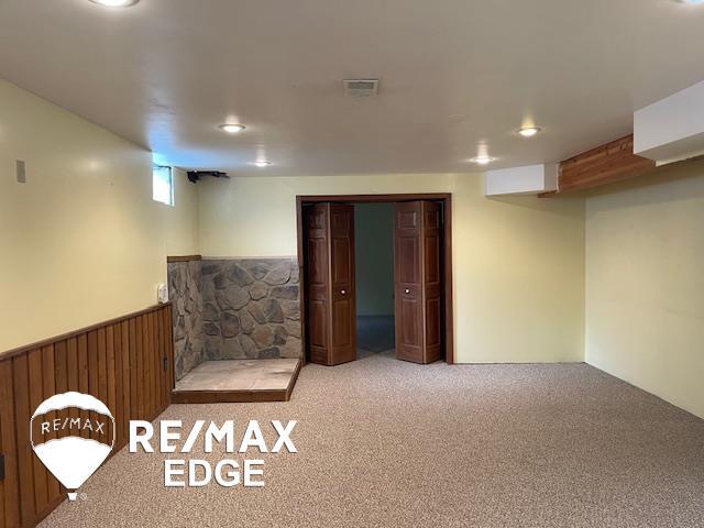 basement with wooden walls and carpet flooring