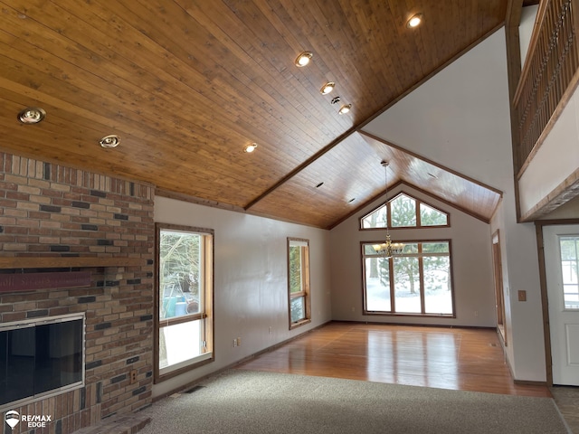 unfurnished living room with an inviting chandelier, high vaulted ceiling, light hardwood / wood-style flooring, and wooden ceiling