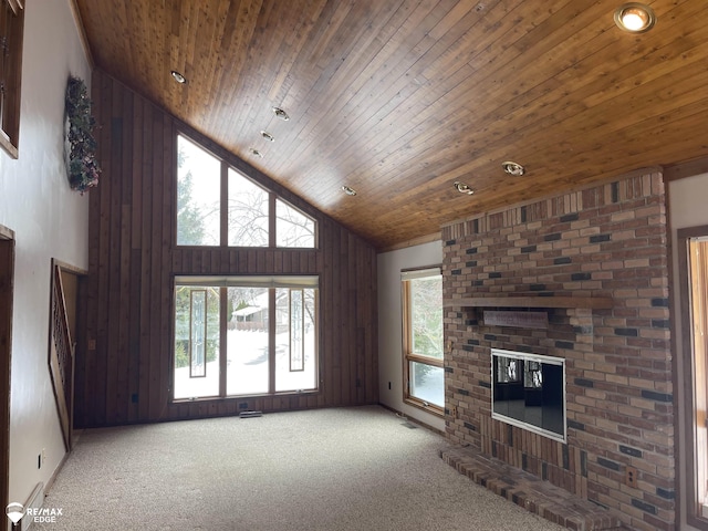 unfurnished living room featuring a brick fireplace, wooden ceiling, carpet, and high vaulted ceiling