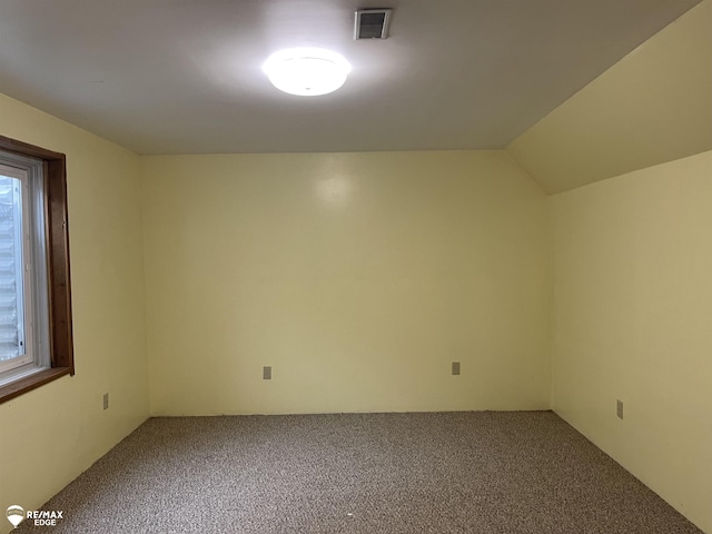 unfurnished room with vaulted ceiling and carpet