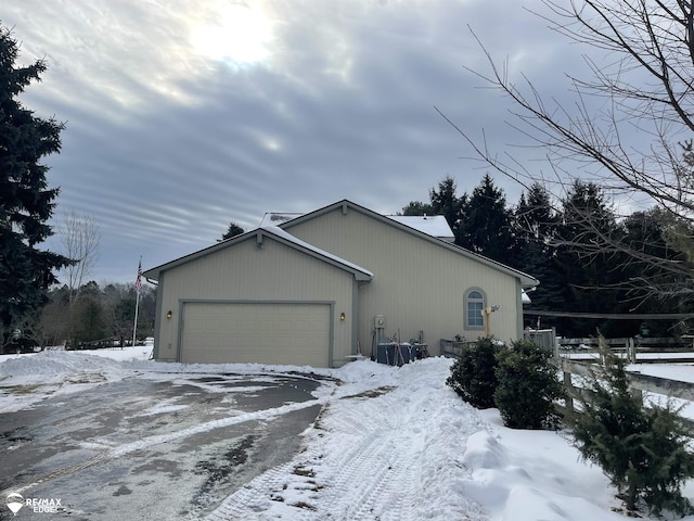 snow covered property with a garage