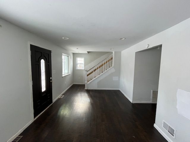 foyer featuring visible vents, stairs, wood finished floors, baseboards, and recessed lighting