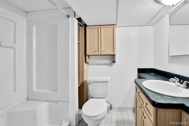 bathroom with a shower, tile patterned flooring, vanity, toilet, and a drop ceiling