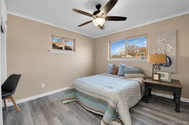 bedroom featuring multiple windows, hardwood / wood-style flooring, and ornamental molding