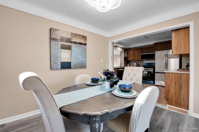 dining space with hardwood / wood-style flooring and sink