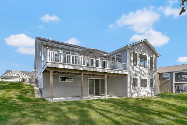 rear view of house featuring a wooden deck, a lawn, and a patio
