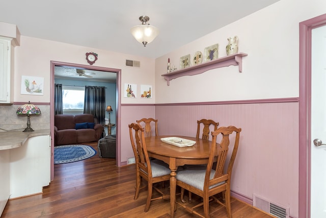 dining room featuring visible vents, dark wood finished floors, and wainscoting