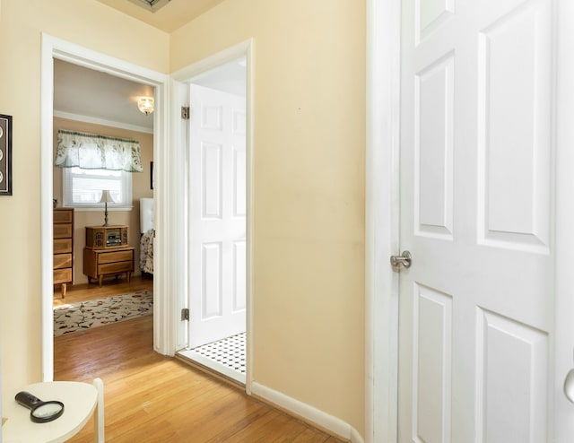 corridor featuring wood finished floors and baseboards