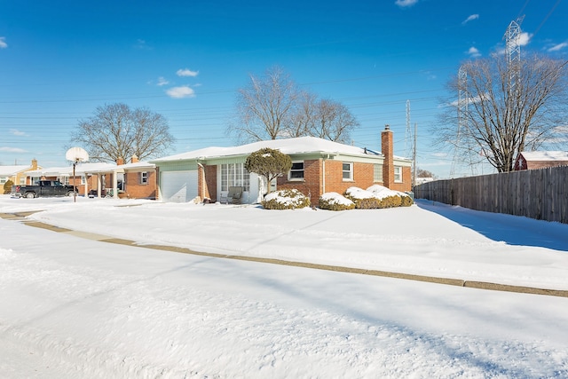 single story home featuring an attached garage, a chimney, fence, and brick siding