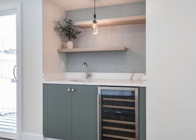 bar featuring hanging light fixtures, wine cooler, indoor wet bar, and a sink