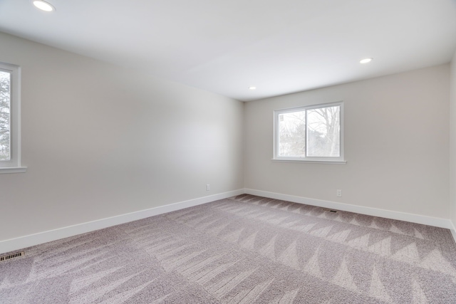 carpeted spare room with recessed lighting, visible vents, and baseboards